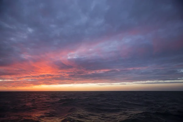 Auringonlaskun aikana näkymä merelle taivasta vasten — kuvapankkivalokuva