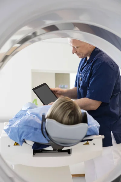 Médico mostrando tablet digital para paciente em fase de TC — Fotografia de Stock