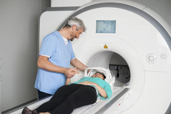 Доктор утешает пациента, лежащего на компьютерной томографии — стоковое фото