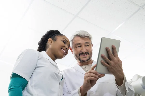 Médicos usando tableta digital en sala de examen — Foto de Stock