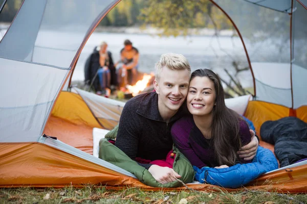 Loving Young Couple Lying In Tent At Lakeshore — Stock Photo, Image