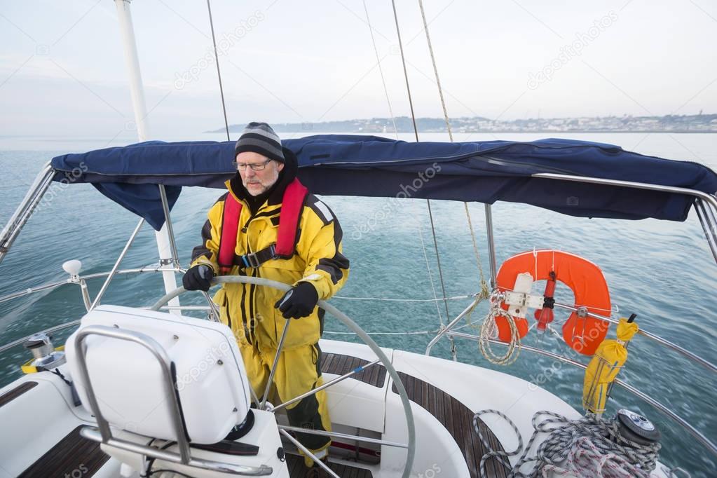 Man Wearing Waterproof Jacket While Steering Yacht In Sea