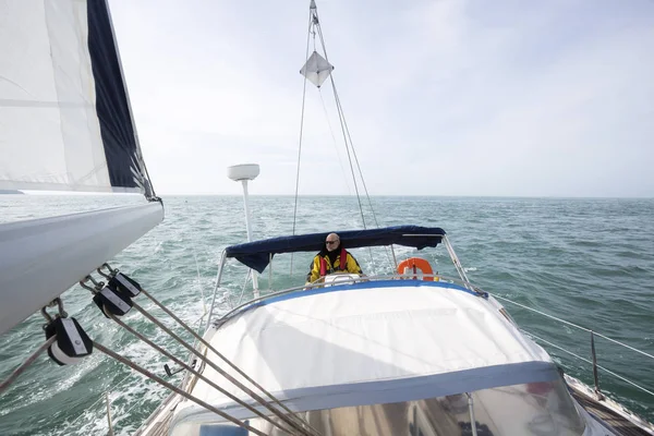 Homem dirigindo iate de luxo no mar no dia ensolarado — Fotografia de Stock