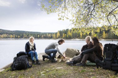Lakeside kamp şenlik için hazırlanıyor adam bakarak arkadaşlar