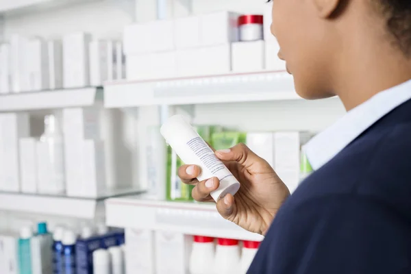 薬局で薬瓶や容器の指示を読んで実業家 — ストック写真