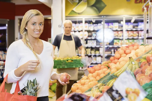 Femme client tenant Apple dans le supermarché — Photo