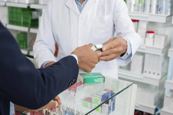 Immagine ritagliata del farmacista che dà la medicina al cliente femminile — Foto Stock