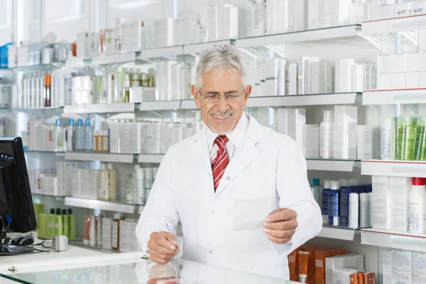 Chimico guardando carta prescrizione a Counter — Foto Stock