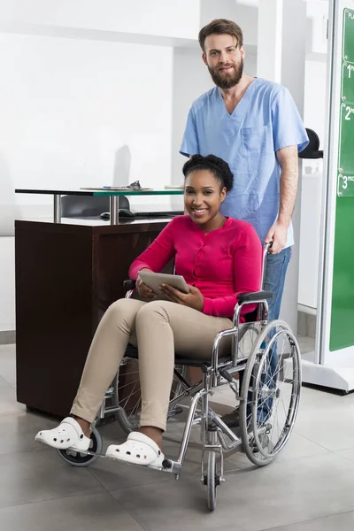 Patient assis en fauteuil roulant pendant que l'infirmière est debout à l'hôpital — Photo