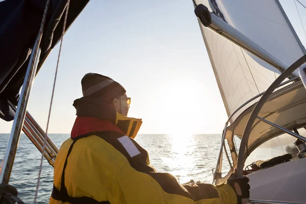 Uomo che indossa giacca impermeabile su yacht in mare — Foto Stock