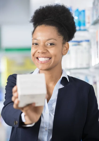 Alegre empresaria mostrando caja de medicina en farmacia —  Fotos de Stock