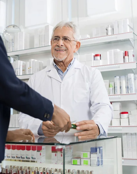 Chimiste donnant la médecine au client en pharmacie — Photo