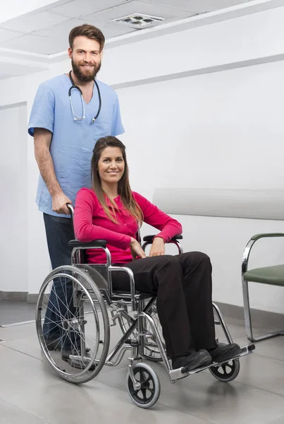 坐在轮椅上护士站在居屋的女病人 — 图库照片