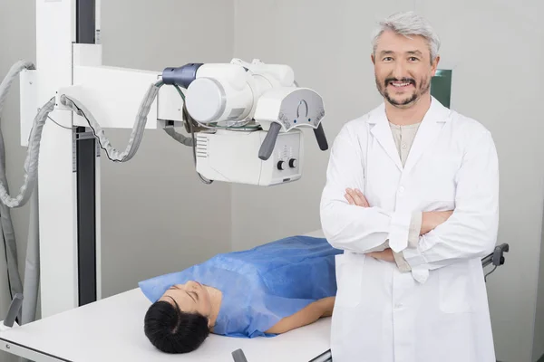 Confident Radiologist Standing By Female Patient Undergoing X-ra — Stock Photo, Image