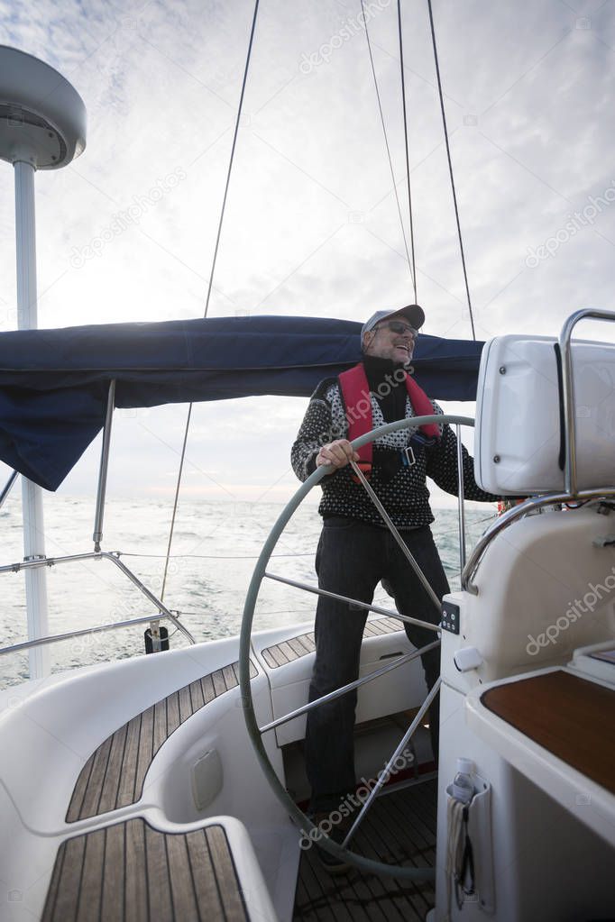 Cheerful Man Steering Wheel Of Yacht During Sunset