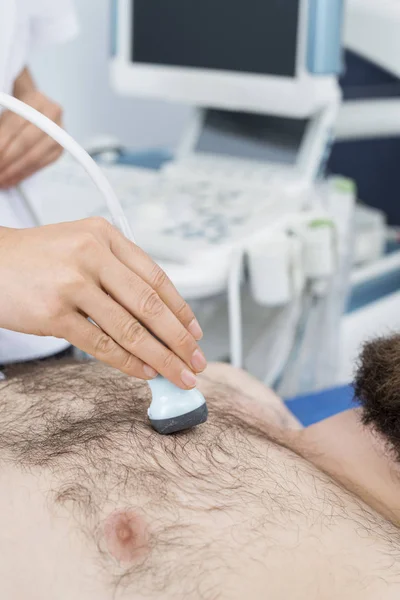 Médico femenino coloca sonda de ultrasonido en el pecho de los pacientes —  Fotos de Stock
