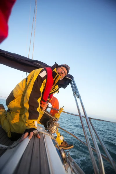 Mann kurbelt Winde auf Jacht im Meer an — Stockfoto
