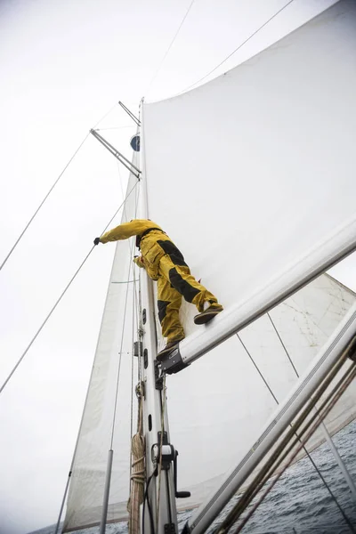 Maturo uomo in piedi su yacht boom contro cielo — Foto Stock