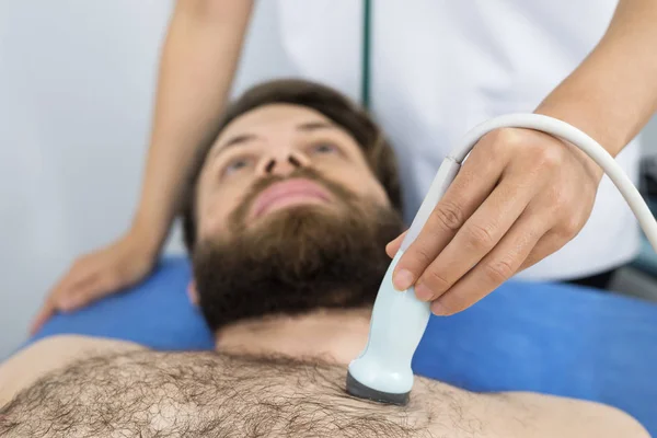 Dokter ultrasone sonde plaatsen op mannelijke patiënten borst — Stockfoto