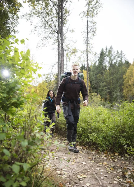 Homem caminhando com amigo feminino na trilha da floresta — Fotografia de Stock