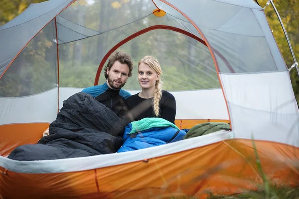 Casal jovem com sacos de dormir na tenda — Fotografia de Stock