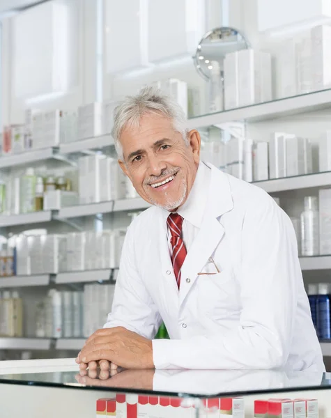 Fiducioso farmacista sorridente mentre si appoggia sul contatore — Foto Stock