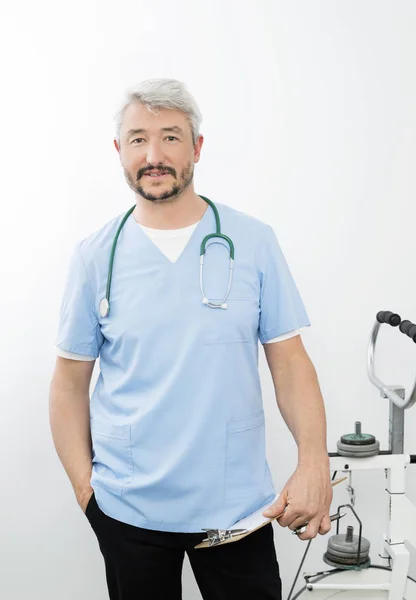 Médico confiante segurando prancheta no hospital — Fotografia de Stock