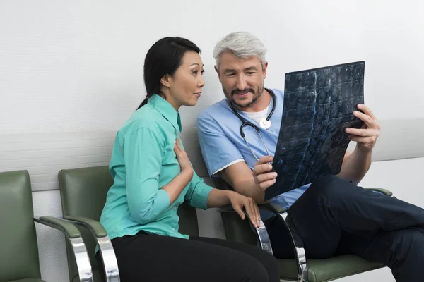 Doctor explicando radiografía al paciente sorprendido — Foto de Stock