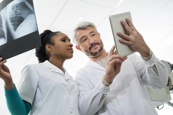 Médicos con rayos X usando tableta digital en el hospital — Foto de Stock