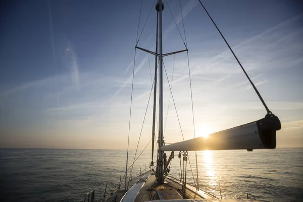 Segelboot, das bei Sonnenuntergang im Meer segelt — Stockfoto