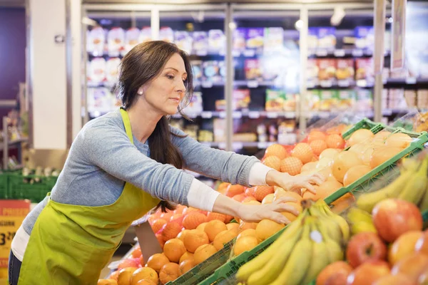 Elárusítónő megszervezése narancs szupermarketben — Stock Fotó