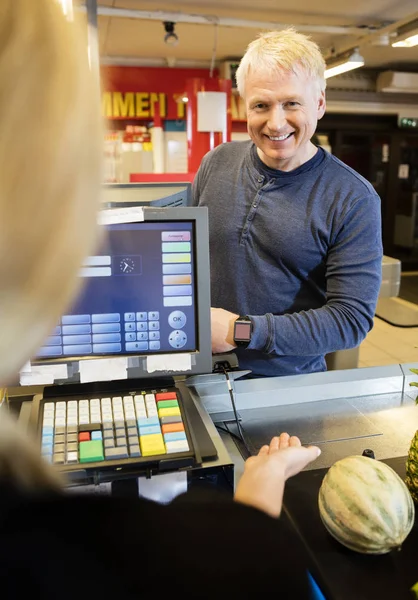 Kunden betalar via Smartwatch medan kassan vägleda honom — Stockfoto