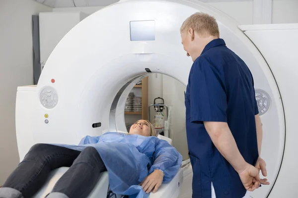 Ακτινολόγος βλέπουν γυναίκα ασθενή ξαπλωμένο στο Mri μηχάνημα — Φωτογραφία Αρχείου