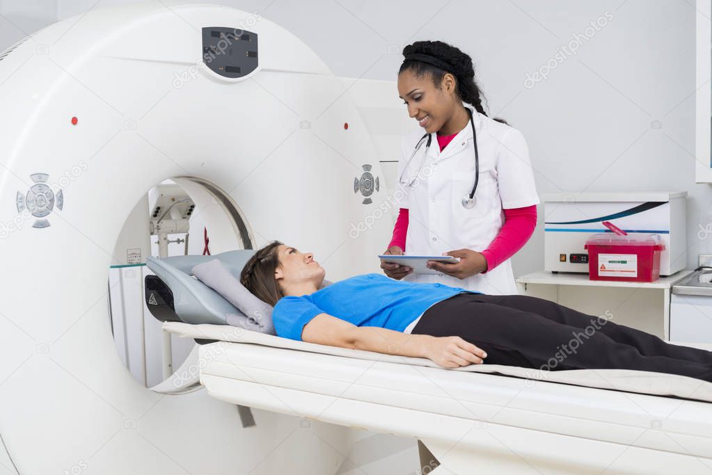 Female Doctor Looking At Patient Undergoing MRI Scan