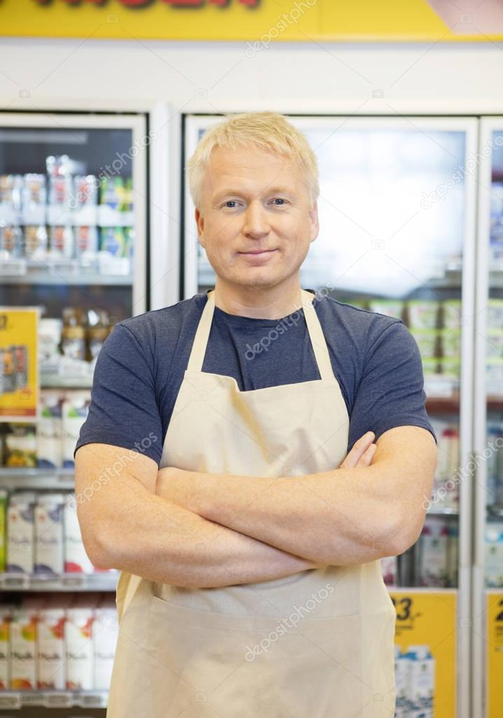 Salesman Standing With Arms Crossed In Grocery Store