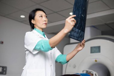 Doktor hasta tomografiye makinede yalan sırasında x-ışını inceleyerek