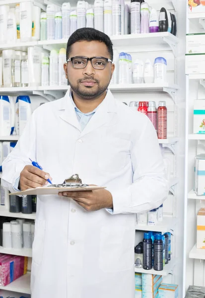 Vertrouwen apotheker klembord houden In apotheek — Stockfoto