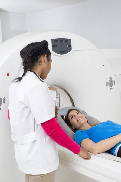 Mulher olhando para o médico feminino enquanto submetendo-se a ressonância magnética — Fotografia de Stock