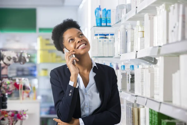 Podnikatelka, používání mobilního telefonu v lékárně — Stock fotografie