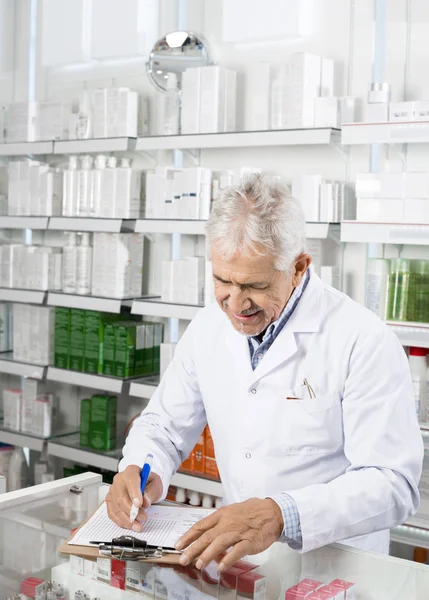 Scrittura del farmacista sugli appunti in farmacia — Foto Stock