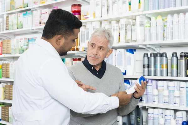 Farmacista assistere il cliente anziano nell'acquisto di prodotti — Foto Stock