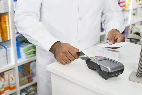 Midsection of Chemist Holding Receipt While Swiping Credit Card —  Fotos de Stock