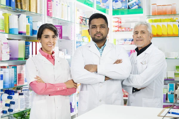 Magabiztos gyógyszerészek állandó keresztbe gyógyszertár — Stock Fotó