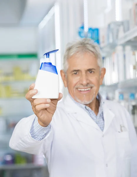 Farmacêutico sorrindo enquanto segurava o dispensador de sabão — Fotografia de Stock