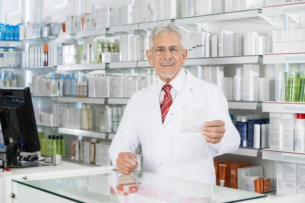 Chimico maschile guardando carta prescrizione a Counter — Foto Stock