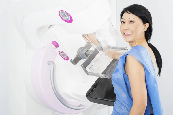 Усміхнена жінка проходить рентгенівський тест мамограми — стокове фото