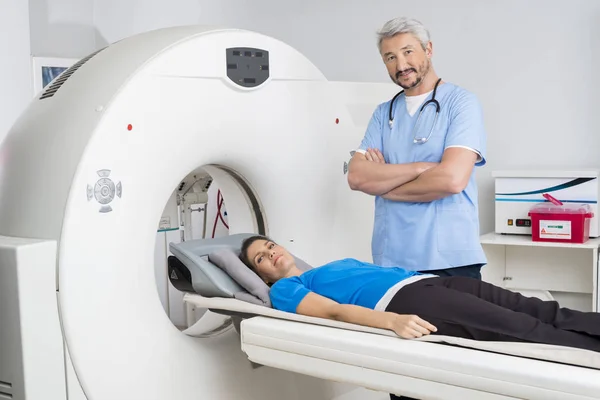 医生站双臂交叉的病人躺在磁共振成像机 — 图库照片