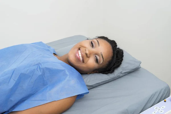Retrato do paciente sorrindo enquanto deitado na cama na clínica — Fotografia de Stock