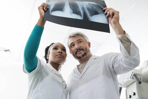 Lekarze płci męskiej i żeńskiej, badanie RTG klatki piersiowej w szpitalu — Zdjęcie stockowe