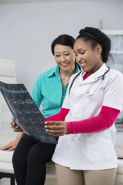 Mujer y médico mirando rayos X de tórax en la sala de examen — Foto de Stock